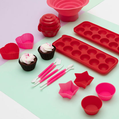 Set of red and pink silicone baking molds on a light green surface