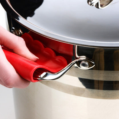 Hand using a red pot holder to safely handle a metal pot on a white background