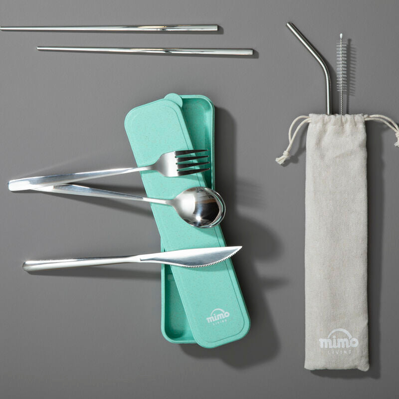 Set of stainless steel cutlery and straws with a green case on a gray background