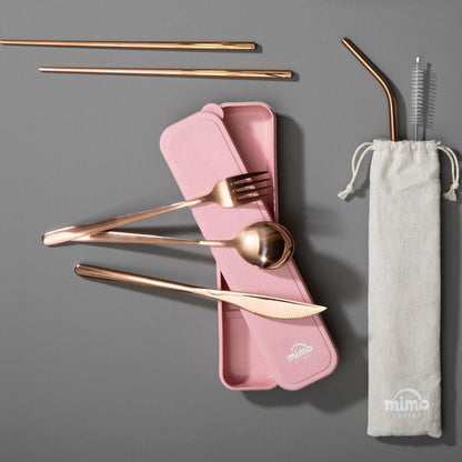 Set of gold cutlery with pink case and straw in a drawstring bag on a gray background