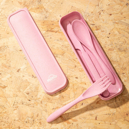 Pink travel cutlery set with case on a wooden surface