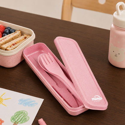 Pink lunch set with fork, knife, and spoon on a wooden table with a bento box and water bottle.