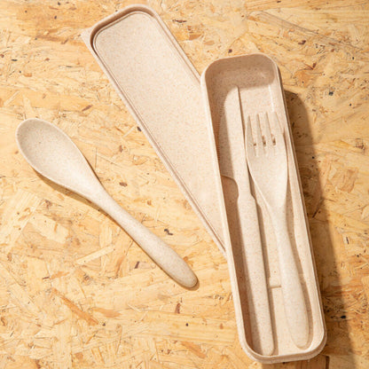 Set of wooden cutlery including a spoon, fork, and knife in a beige case on a wooden surface.
