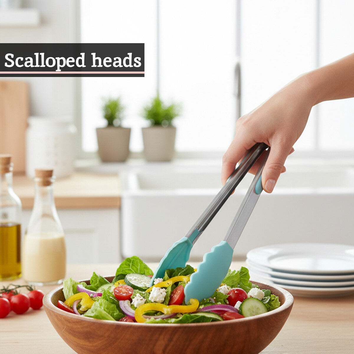 Person using salad tongs to serve a salad from a wooden bowl in a kitchen setting.