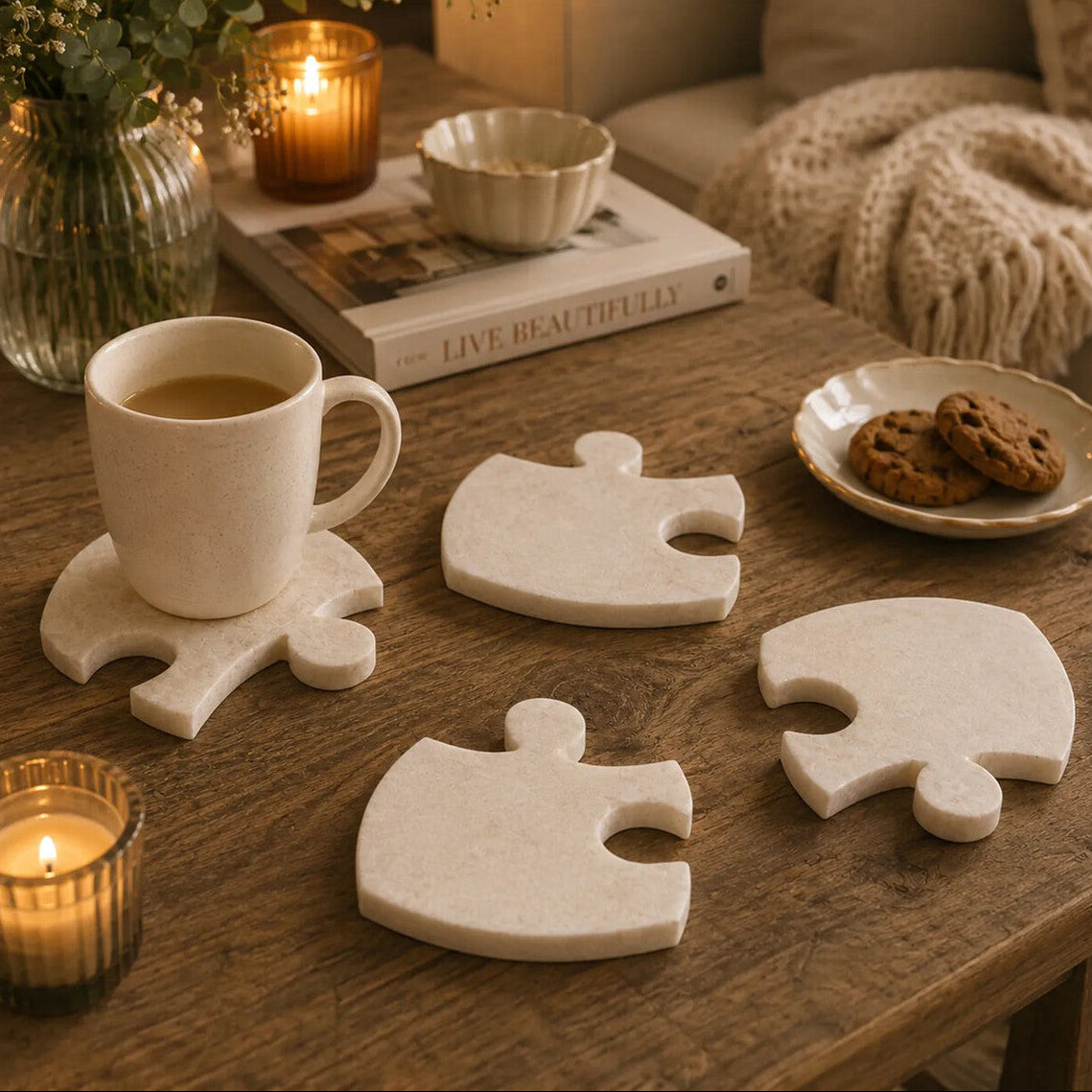 Coasters shaped like puzzle pieces on a wooden table with a cup of coffee, cookies, and candles.