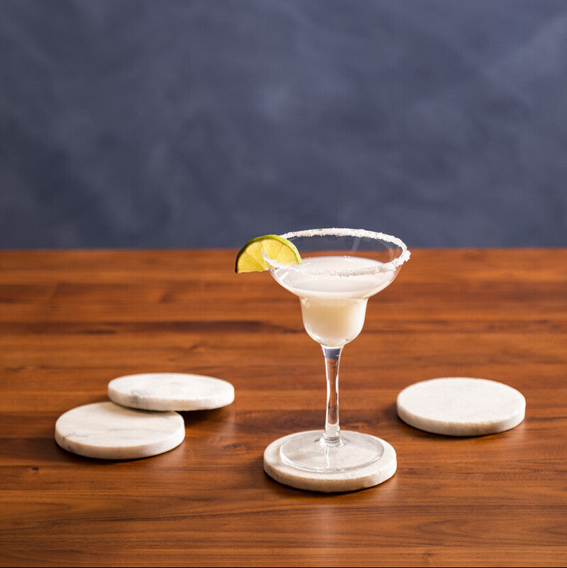 Cocktail in a martini glass with a lemon twist on a wooden table against a dark background