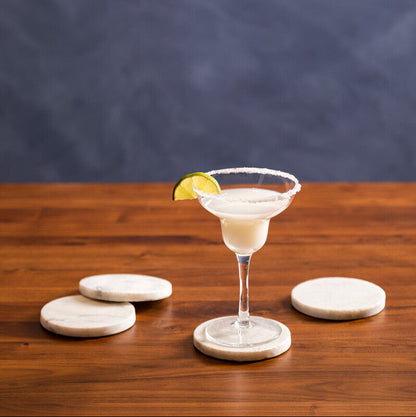 Cocktail in a martini glass with a lemon twist on a wooden table against a dark background