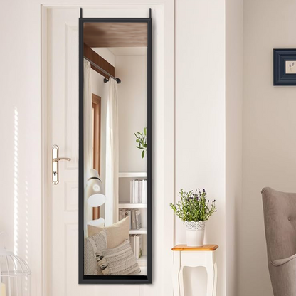 Full-length mirror leaning against a wall in a room with a chair and small table.