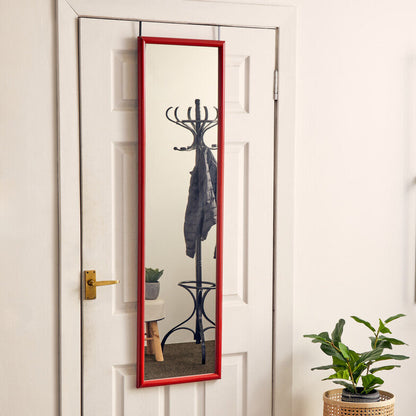 Full-length mirror with red frame leaning against a white door, with a plant and small table in the foreground.