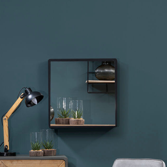 Modern interior with wooden cabinet, gray chair, and decorative items against a dark blue wall.
