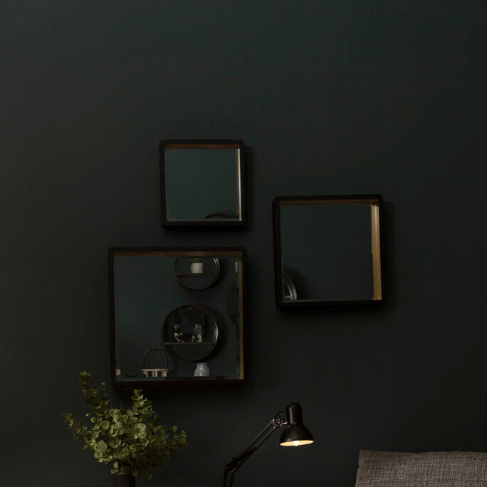 Cozy living room with a gray armchair, coffee table, and decorative items against a dark wall.