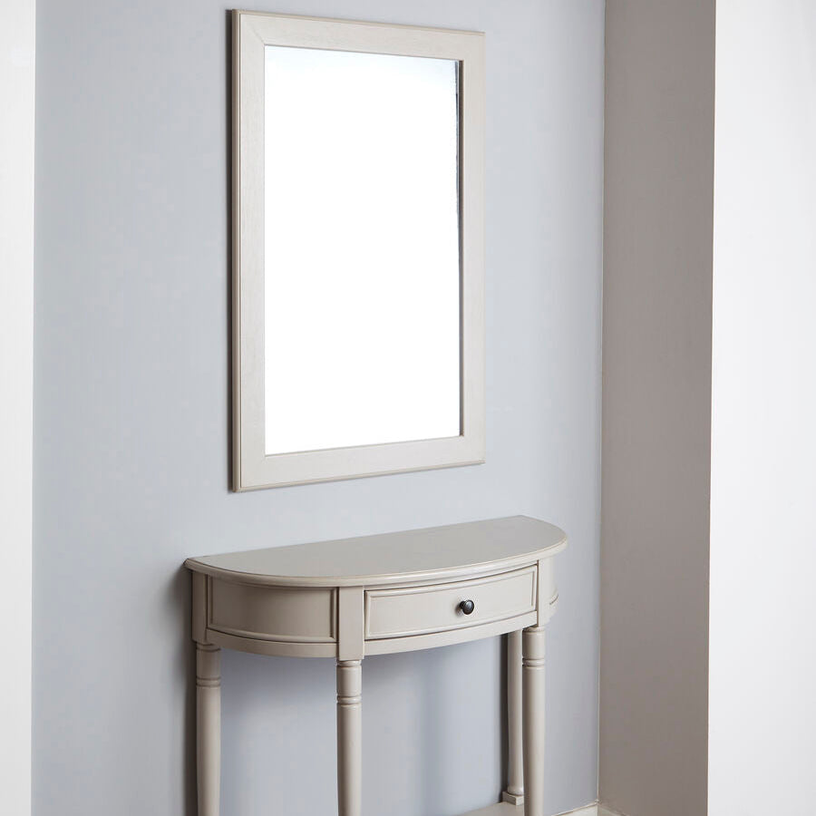 Small console table with a mirror above it against a light gray wall.