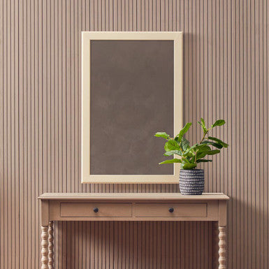 Console table with a mirror and plant against a striped wall.