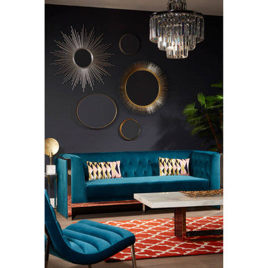 Modern living room with a blue sofa, decorative mirrors, and a chandelier.