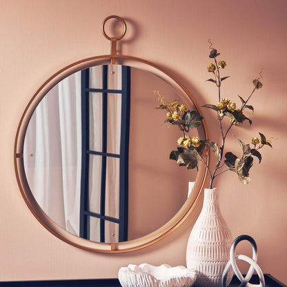 Round mirror with wooden frame on a wall with decorative items below.