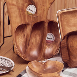 Wooden tableware set on a wooden table with a checkered tablecloth.