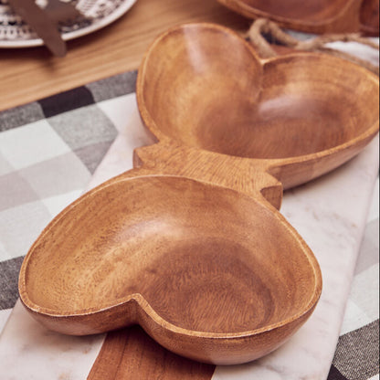 Wooden heart-shaped bowl on a checkered tablecloth with marble base