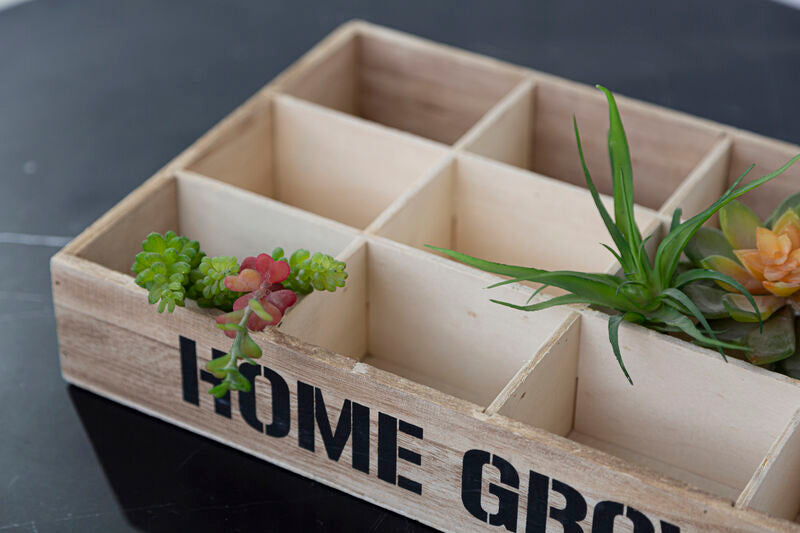 Wooden planter box with compartments labeled &