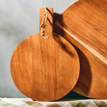 Two wooden cutting boards on a checkered tablecloth with a neutral background
