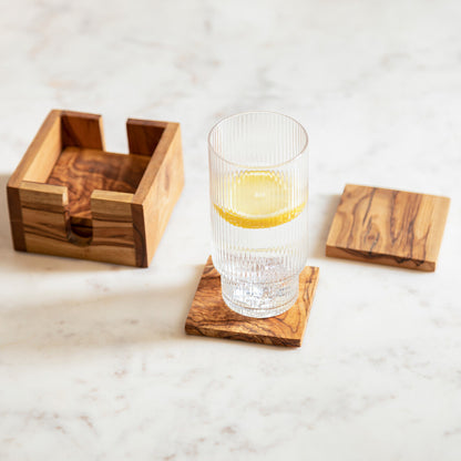 Wooden coasters with a glass of water on a marble surface