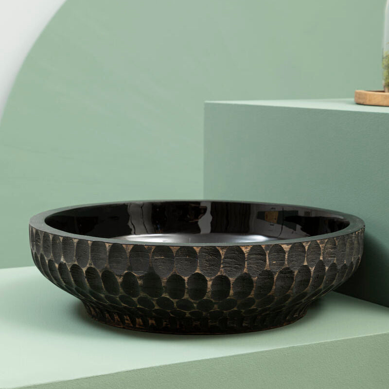 Black textured bowl on a light green surface