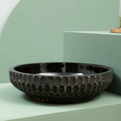 Black textured bowl on a light green surface