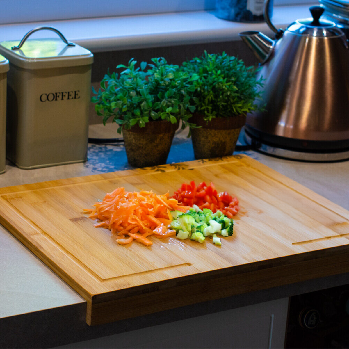 Wooden cutting board with chopped vegetables on a kitchen counter.