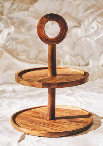 Wooden tiered stand with circular design on a textured white background