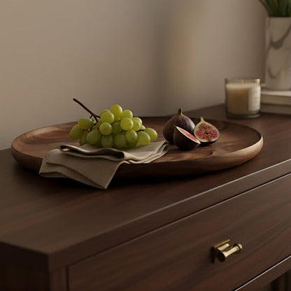 Wooden dresser with a tray of grapes and figs, a candle, and a vase of white tulips.