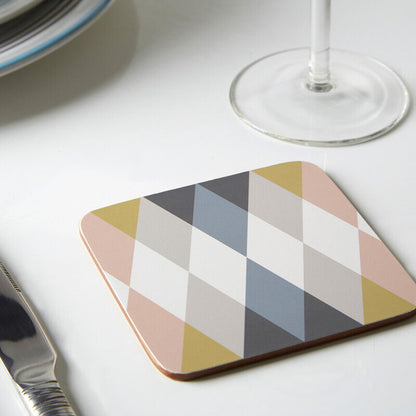 Hexagonal coaster with geometric pattern on a table with knife, glass, and plates.