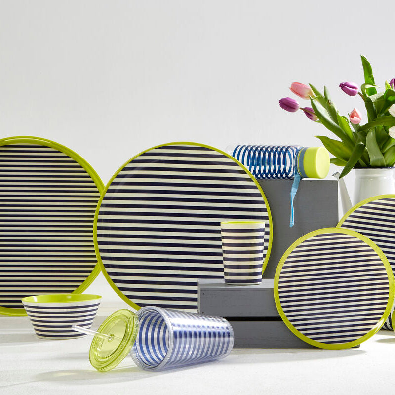 Striped tableware set with green rims on a white surface, including plates, bowls, and cups.