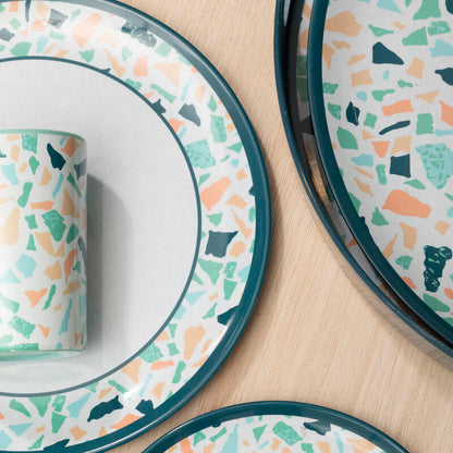 Dinnerware set with terrazzo pattern on a beige surface
