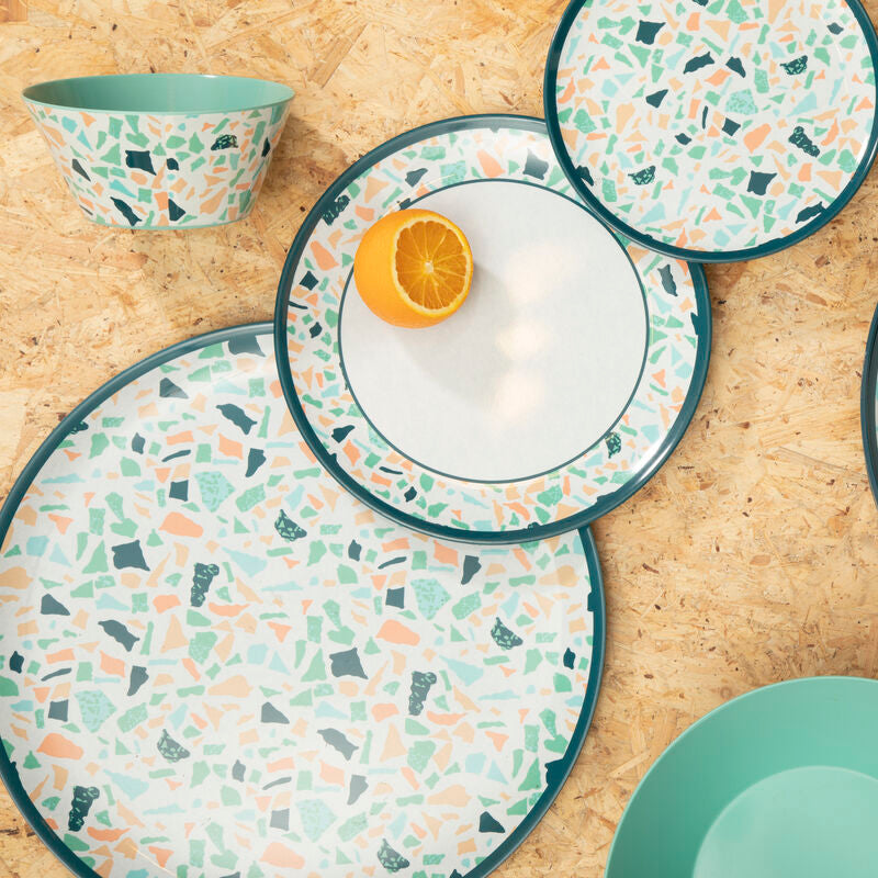 Set of ceramic plates and bowls with terrazzo pattern on a wooden surface