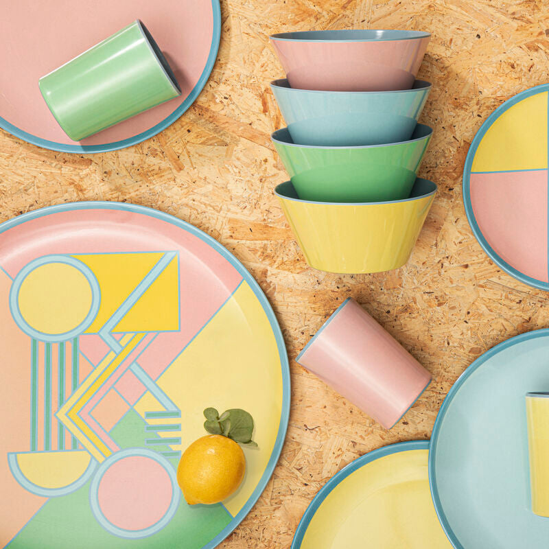 Colorful ceramic plates and bowls on a wooden surface