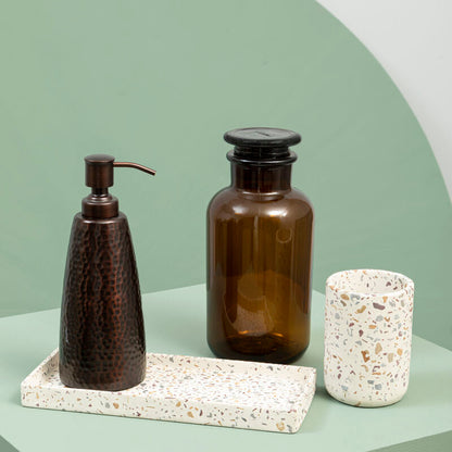 Bathroom accessories including a soap dispenser, bottle, and scrubber on a tray with a green and white background.
