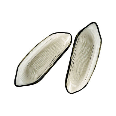 Two oval-shaped ceramic plates with black rims on a white background