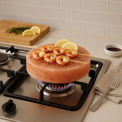 Shrimp skewers on a pink stone plate over a gas stove with lemon slices and herbs.