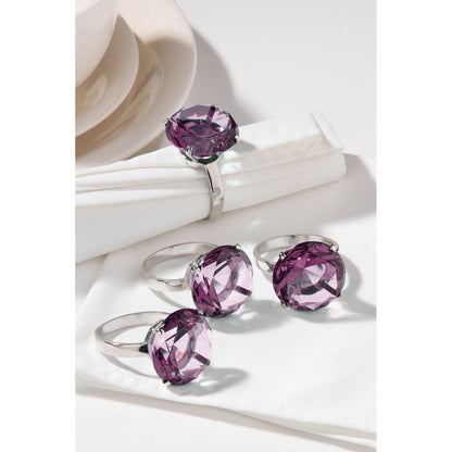 Silver rings with purple gemstones on a white surface