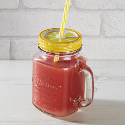 Glass mason jar with yellow lid and straw on a white brick background
