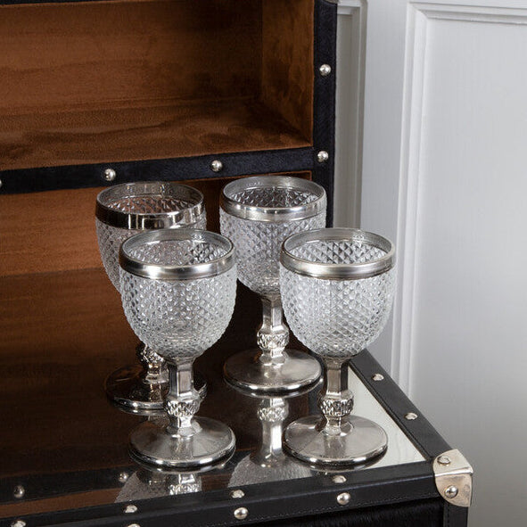 Decorative glass goblets on a black dresser with silver accents