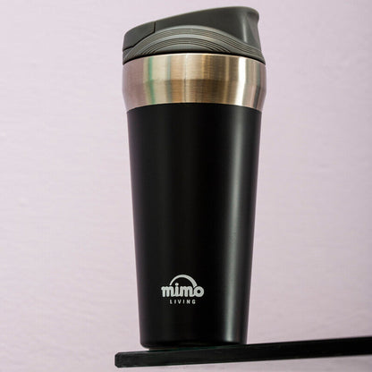 Black insulated travel mug with silver lid on a light purple background