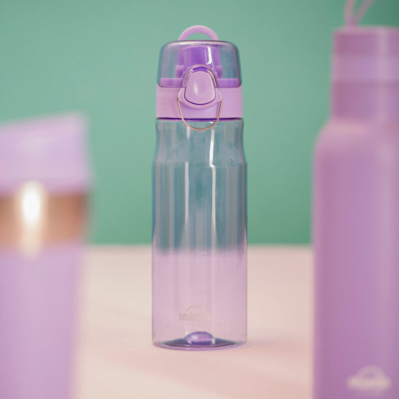 Purple water bottle with a pink cap on a light pink surface against a green background