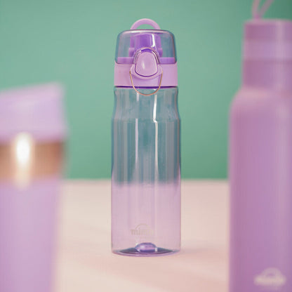 Purple water bottle with a pink cap on a light pink surface against a green background