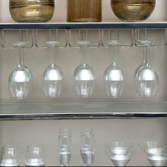 Shelves with decorative glass items and wine glasses in a kitchen setting