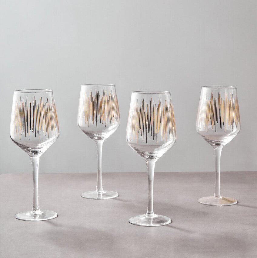 Four wine glasses with decorative patterns on a light gray background