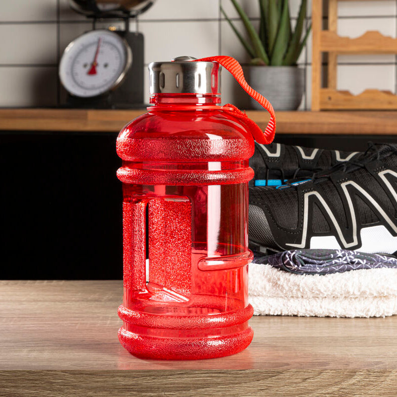 Red water bottle on a kitchen counter with sneakers and a scale in the background
