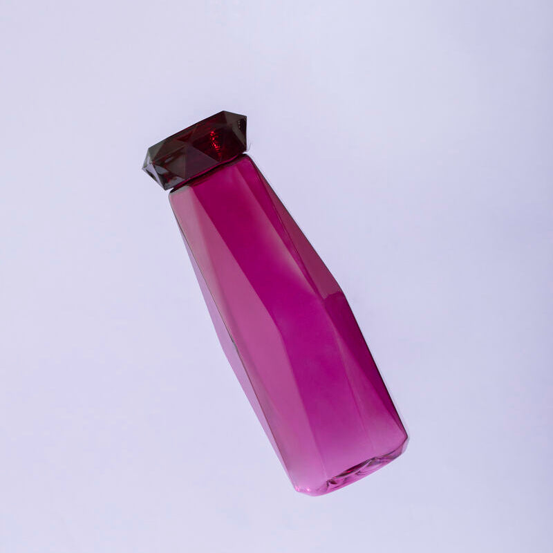Pink glass bottle with a dark brown cap on a light purple background
