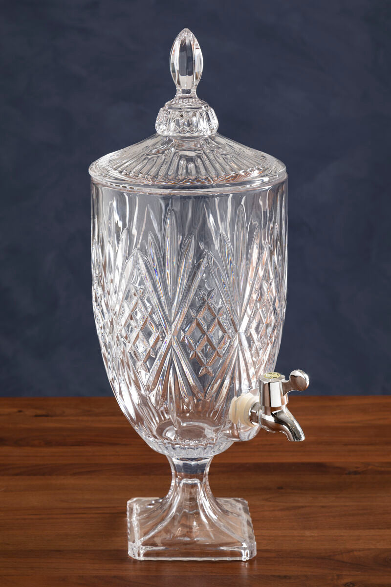 Clear glass beverage dispenser with a lid on a wooden surface