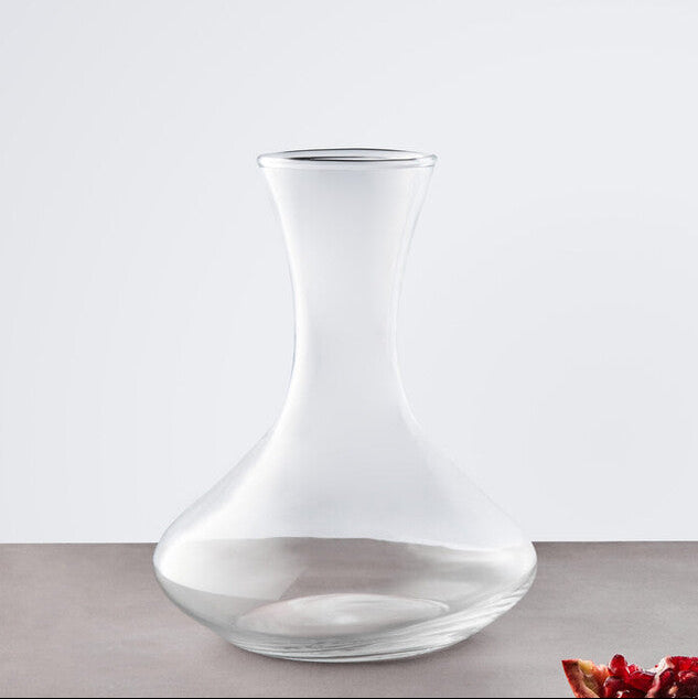 Clear glass carafe on a gray surface with a white background