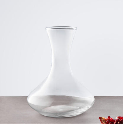 Clear glass carafe on a gray surface with a white background